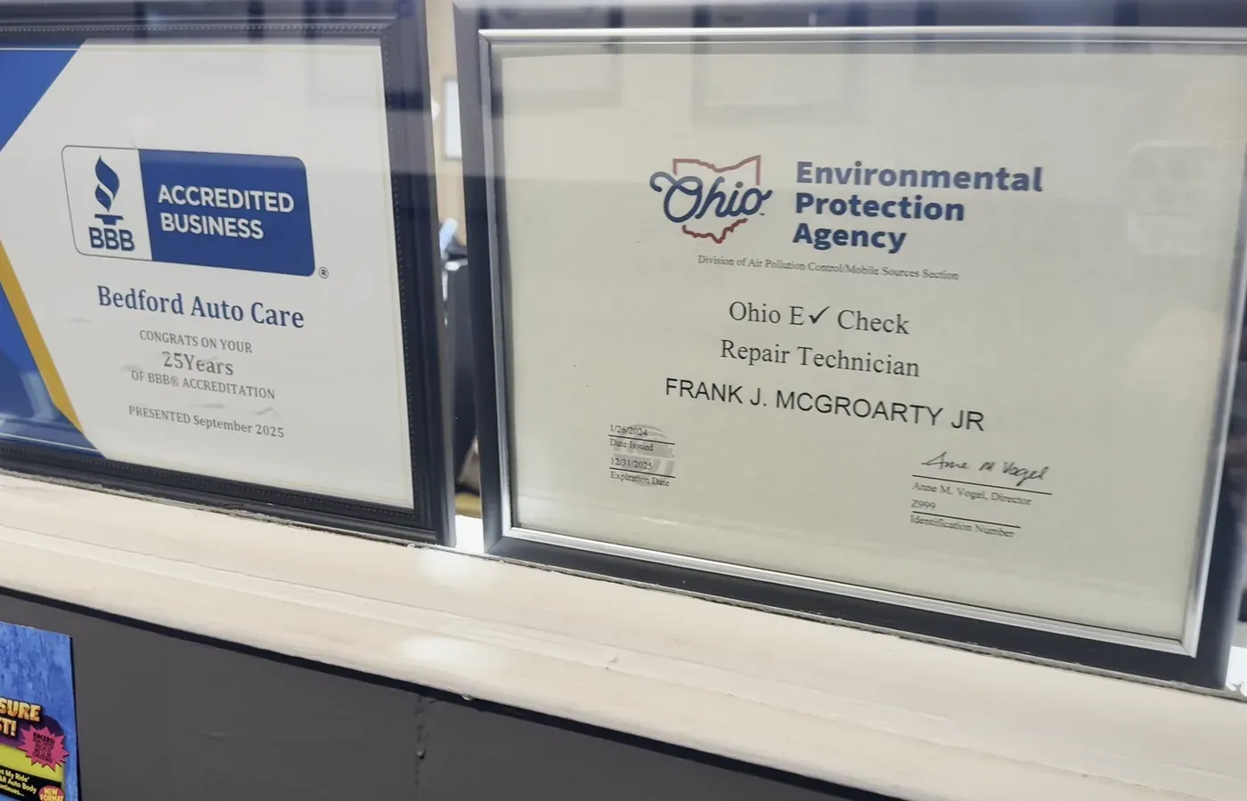 BBB Accredited Business and Ohio EPA E-Check repair technician certificates on the counter at Bedford Auto Care